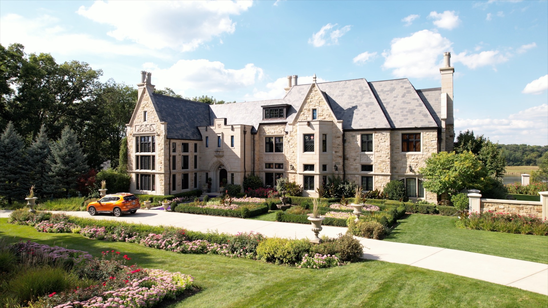 Large stone property exterior surrounded by landscaped grounds