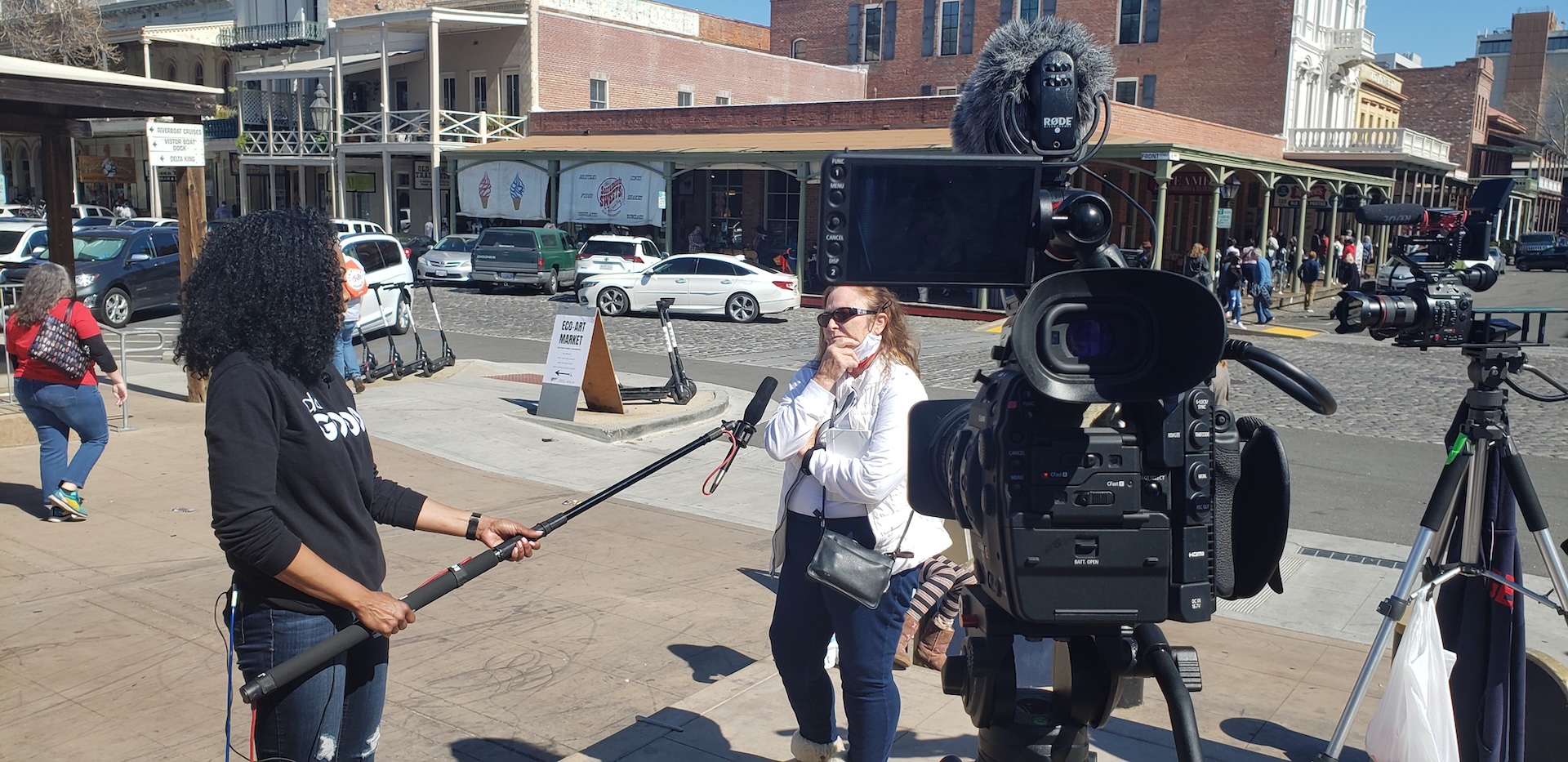 On-location video production setup with cameras and a boom microphone